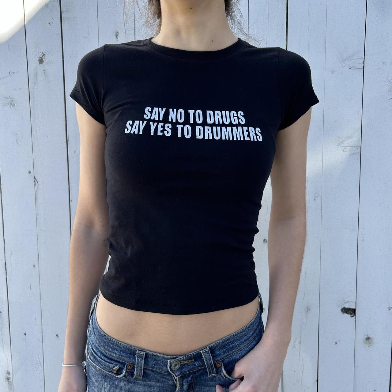 Model wearing black baby tee with "Say No to Drugs Say Yes to Drummers" written in white across the chest.