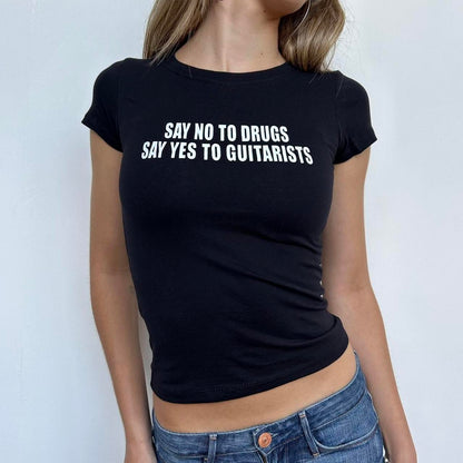 Model wearing black baby tee with "Say No to Drugs Say Yes to Guitarists" written in white across the chest.