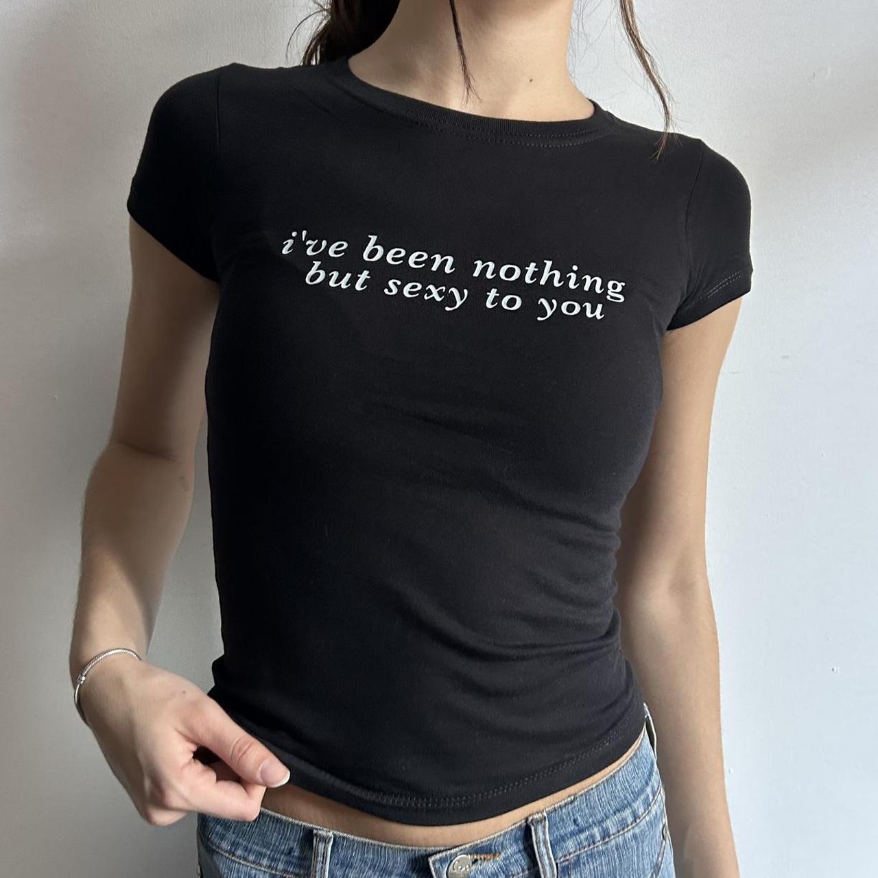 Model wearing black baby tee with "I've Been Nothing But Sexy To You" written in white across the chest.