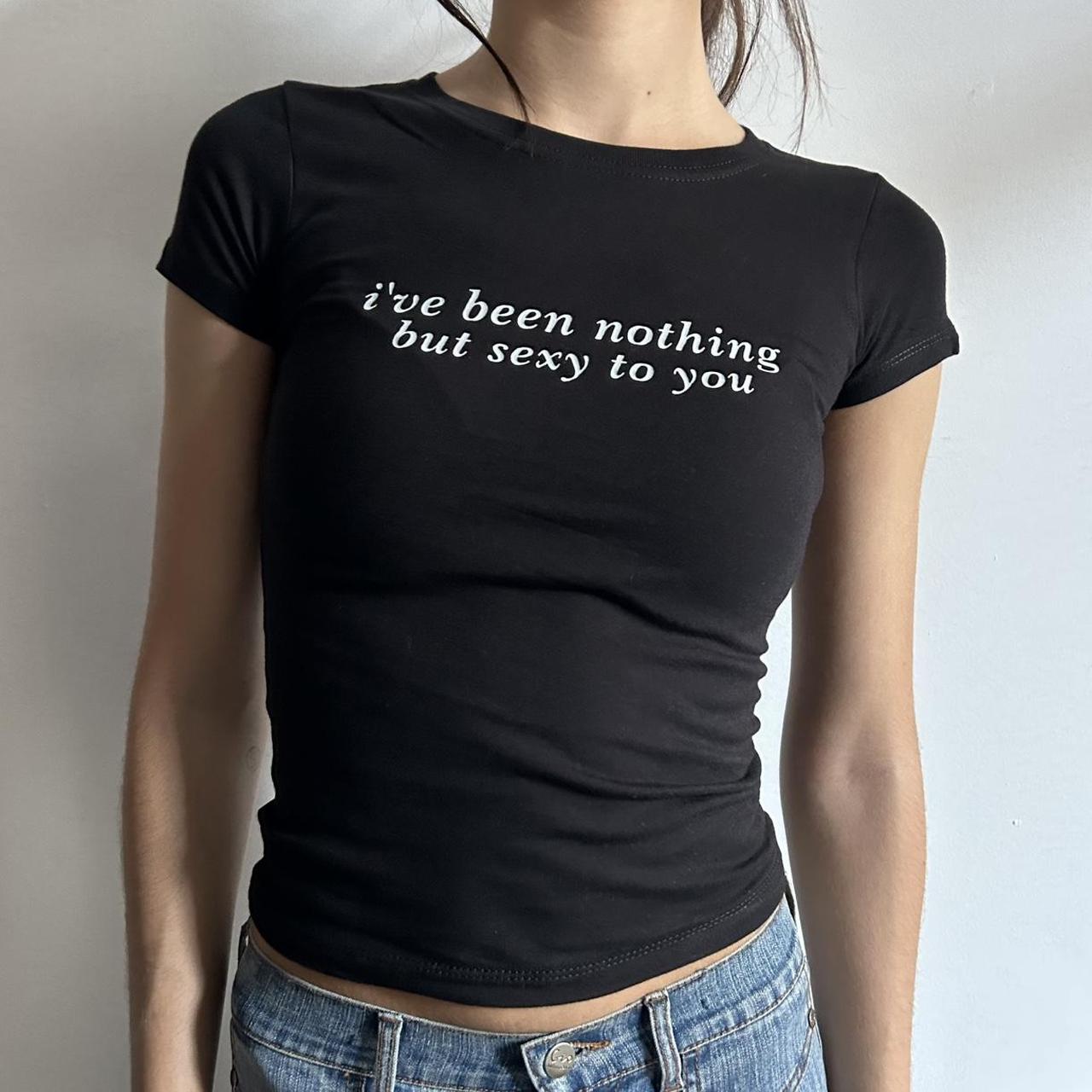 Model wearing black baby tee with "I've Been Nothing But Sexy To You" written in white across the chest.