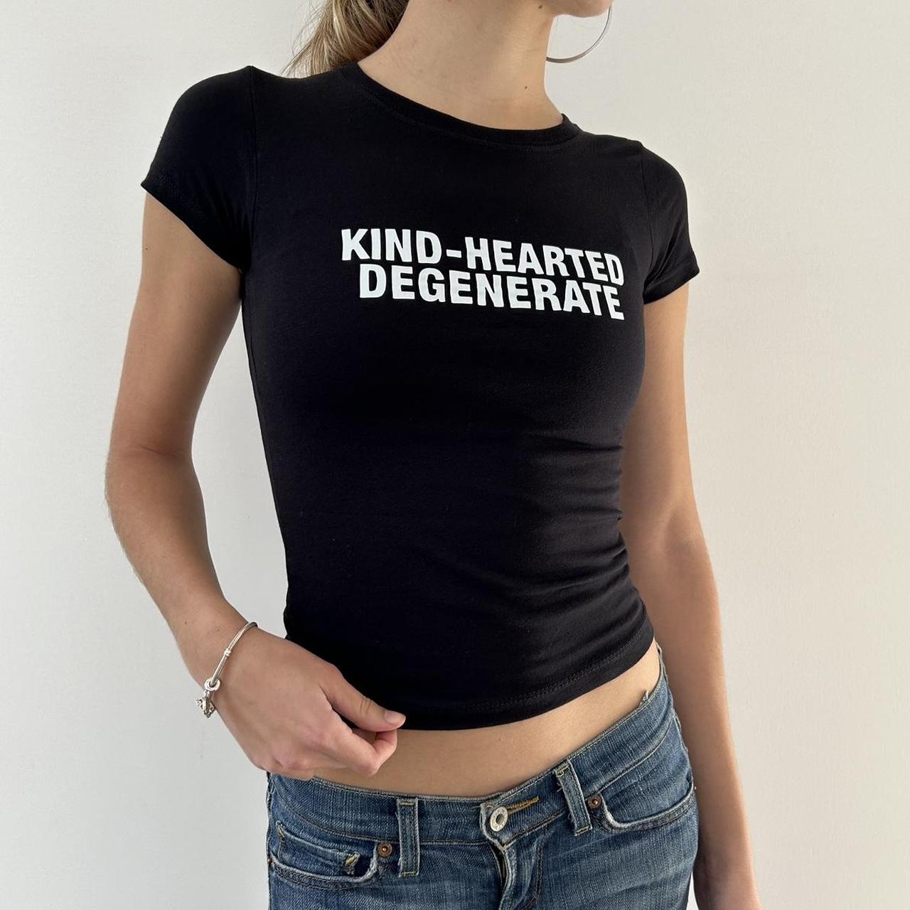 Model wearing black baby tee with "Kind-Hearted Degenerate" written in white across the chest.