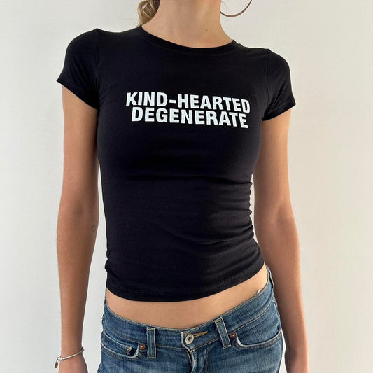 Model wearing black baby tee with "Kind-Hearted Degenerate" written in white across the chest.
