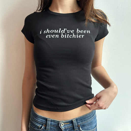 Model wearing black baby tee with "Should've Been Even Bitchier" written in white across the chest.