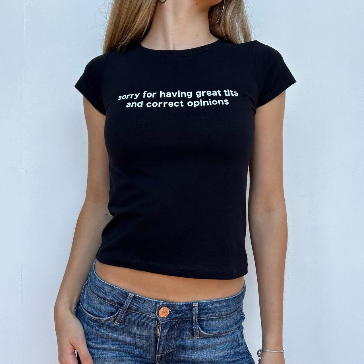 Model wearing black baby tee with "Sorry for Having Great Tits and Correct Opinions" written in white across the chest.